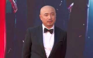 徐峥黑西装亮相表情略囧 双手背后气场十足
